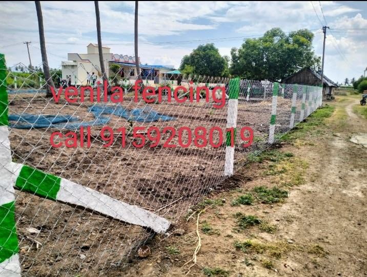 Chain-link fence with green and white posts near a residential site