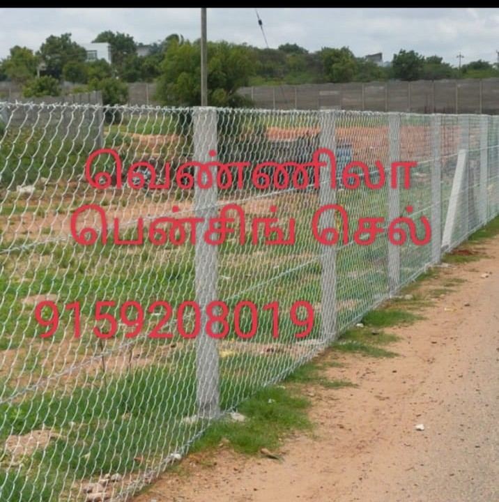Chain-link mesh fencing with painted posts on an open site